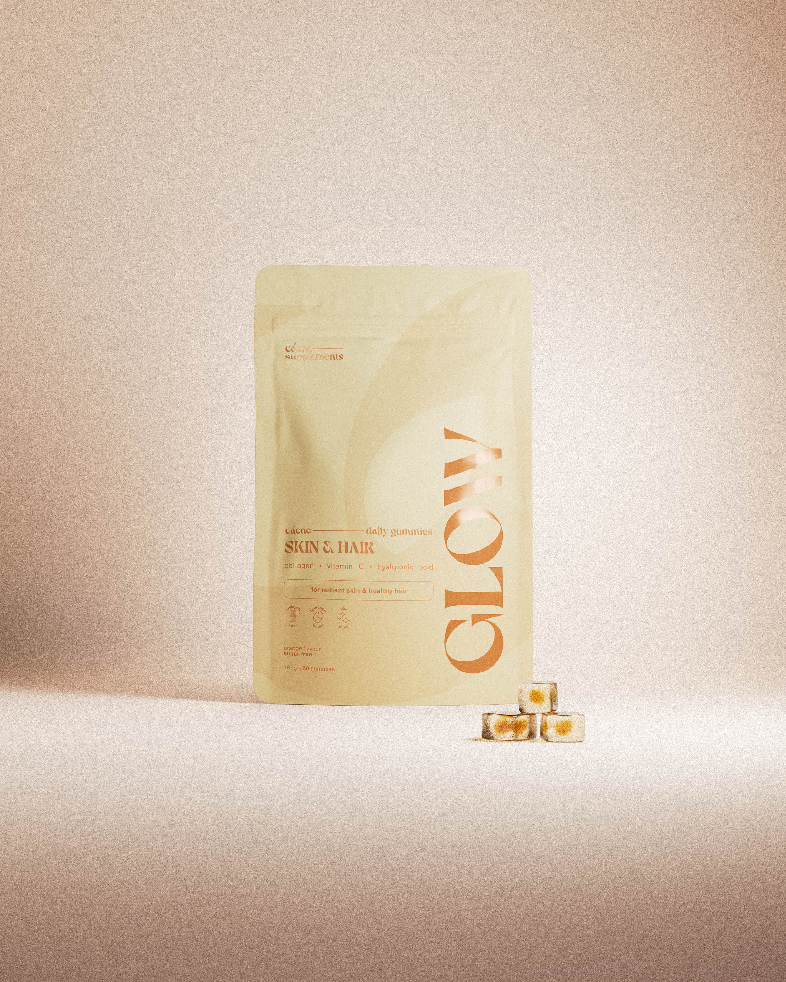 glow gummies-påse med tre orange gummies på varm studiobakgrund